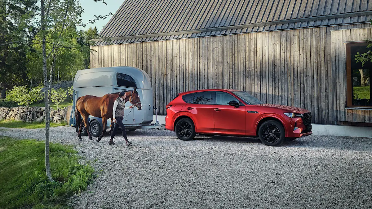 Mazda CX-60 junto a reboque para cavalos
